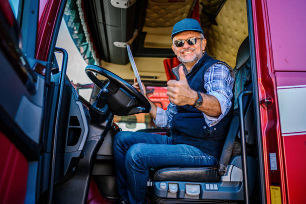Professional truck driver holding thumbs up in truck cabin Professional truck driver holding thumbs up in truck cabin passenger cabin photos stock pictures, royalty-free photos & images