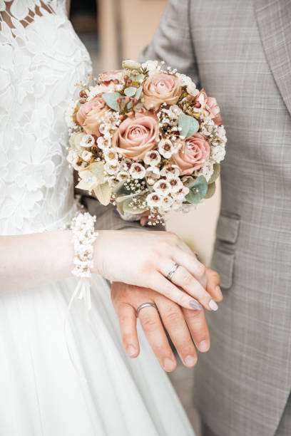 istock Hands with wedding rings and a flower bouquet 1309892236