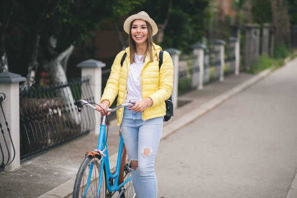 istock Pretty young woman walking and pushing her bicycle. 1309893432