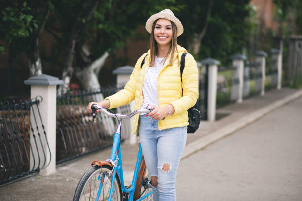 istock Pretty young woman walking and pushing her bicycle. 1309893436