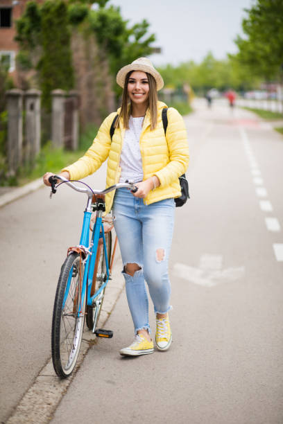 istock Pretty young woman walking and pushing her bicycle. 1309893446