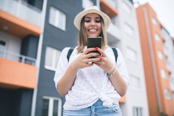 istock Young pretty woman text messaging through smart phone. 1309893595