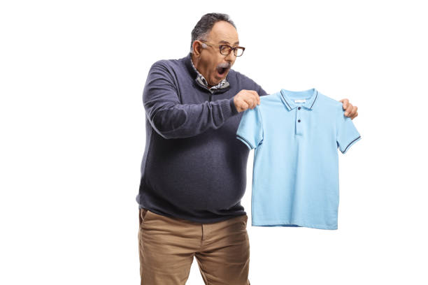 Shocked mature man looking at a shrunken t-shirt Shocked mature man looking at a shrunken t-shirt isolated on white back chubby arab stock pictures, royalty-free photos & images