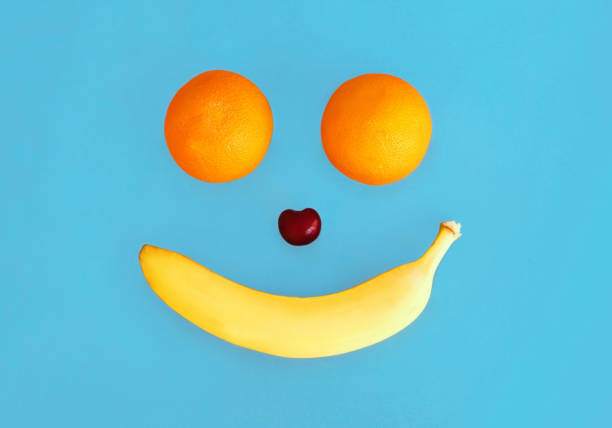 istock Two oranges and banana fruits on a blue background 1309894614