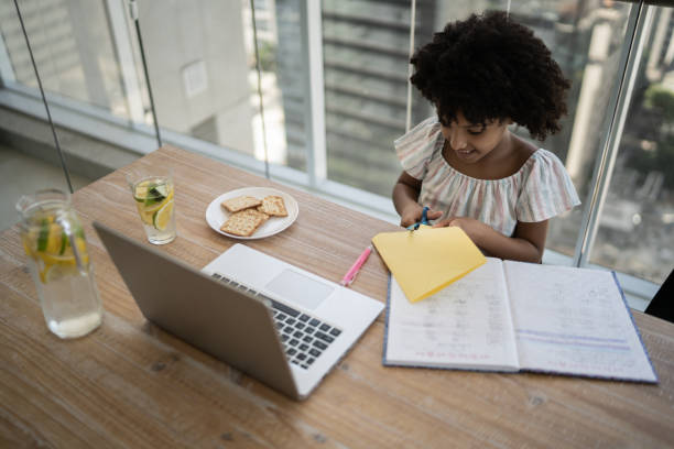 istock Girl cutting paper during homeschooling activity 1309901807