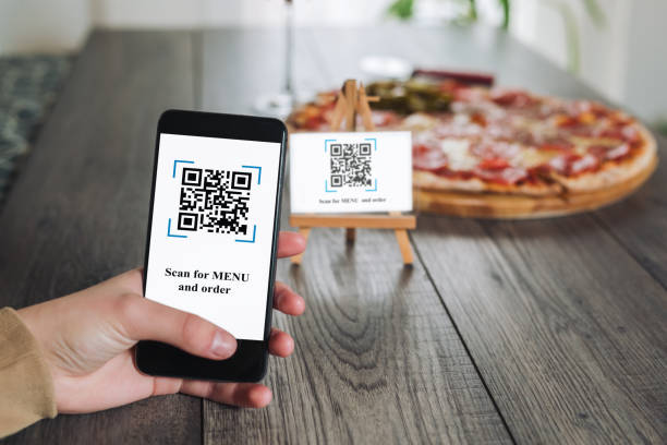 istock Women's hands using the phone to scan the qr code to order pizza. 1309902487