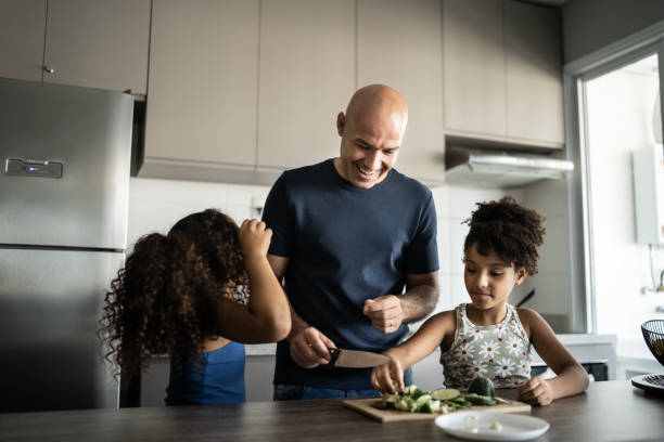 istock Father cooking with daughters at home 1309902598