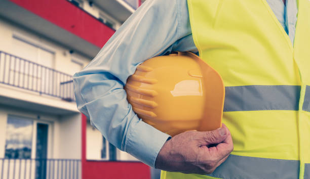 istock Close-up of constructor holding helmet building background 1309904119