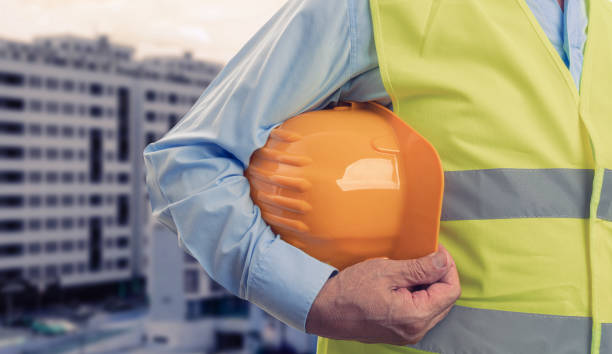 istock Close-up of construction worker holding protective hardhat 1309904150