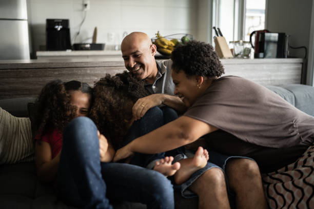 istock Parents tickling daughters at home 1309905445