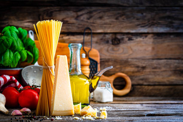 Raw uncooked spaghetti with ingredients like tomato garlic and a glass with olive oil, Macro Photography