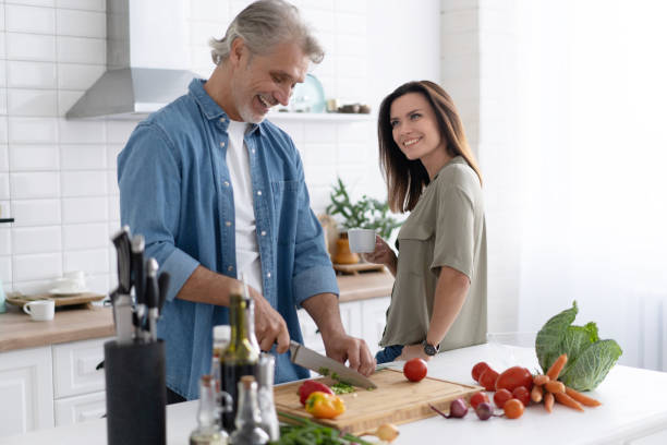 istock Couple cooking together in their kitchen at home. 1309906157