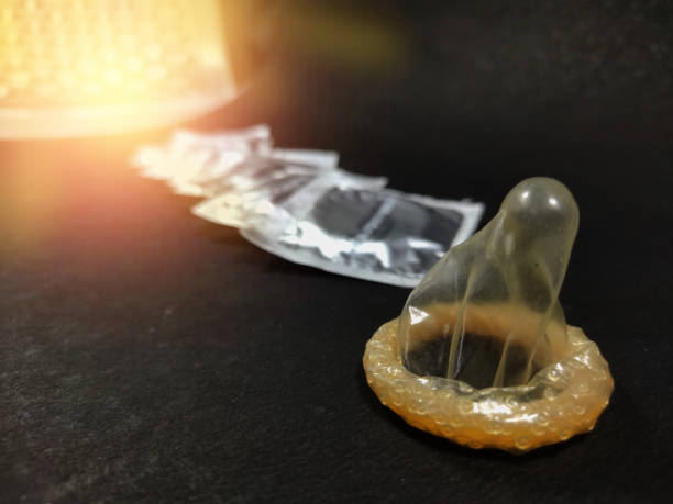 남성 피임 방법 콘돔은 텍스트 공간이있는 검은 배경에 패킷 전에 보관. - condom sex education contraceptive aids 뉴스 사진 이미지