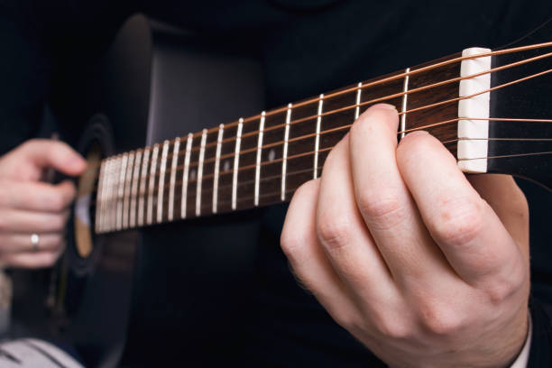istock Playing black guitar guitar, hands close up 1309907274