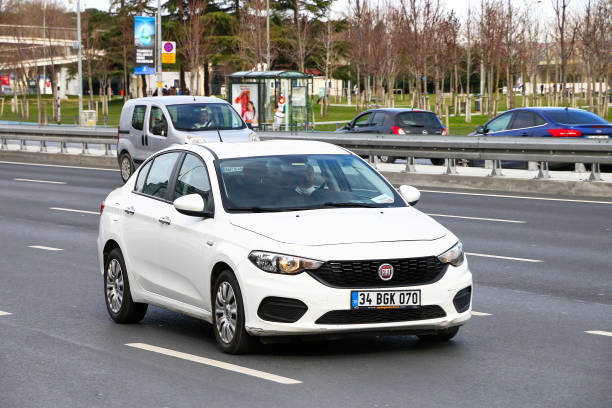 FIAT Aegean Istanbul, Turkey - February 11, 2021: White saloon car FIAT Egea in the city street. little fiat car stock pictures, royalty-free photos & images