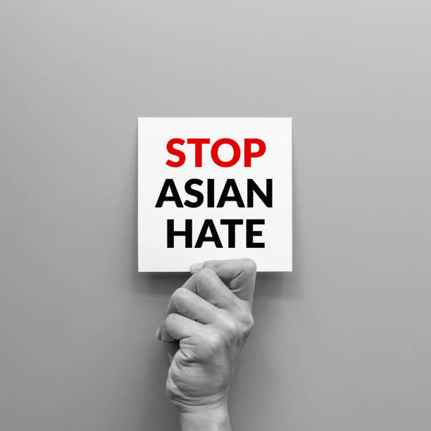 stop Asian hate concept. hand holding card paper sheet with word stop Asian hate for poster of campaign. stop Asian hate concept. hand holding card paper sheet with word stop Asian hate for poster of campaign. apartheid sign stock pictures, royalty-free photos & images