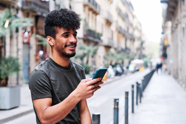 istock a young hipsanic man using his mobile phone outdoors in a cloudy day 1309908836
