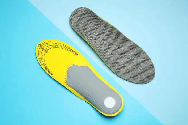 Photo of Orthopedic insoles on light blue background, flat lay