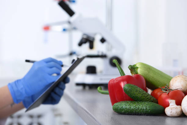 istock Fresh vegetables on table, scientist proceeding quality control in laboratory 1309909180