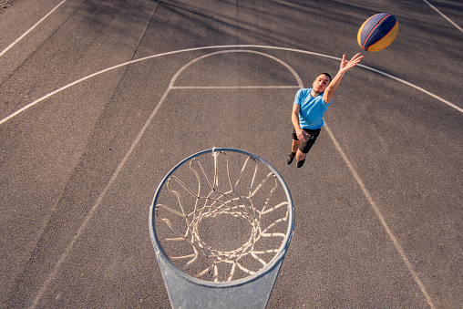 Young basketball player jumping towards the hoop