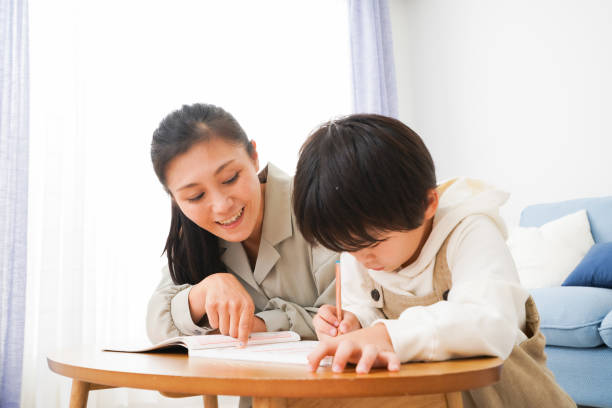 istock A boy studying with his mother at home 1309917372