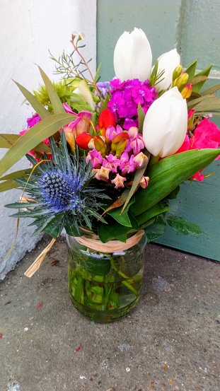 Beautiful bunch of flowers in a jar waiting to surprise the homeowner when they open the door