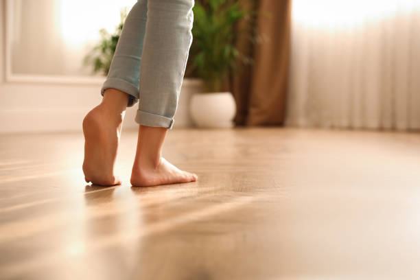 femme pieds nus à la maison, plan rapproché. système de chauffage au sol - pieds nus photos et images de collection