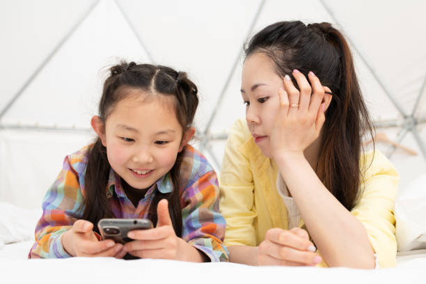 istock Mother and daughter looking at smartphone 1309921091