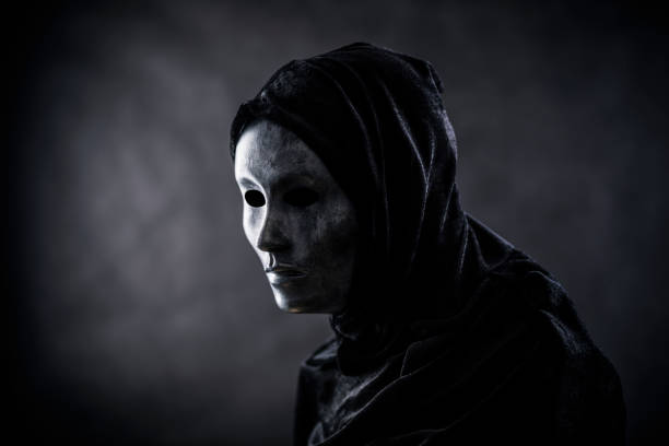 istock Scary figure with hooded cape in the dark 1309922854