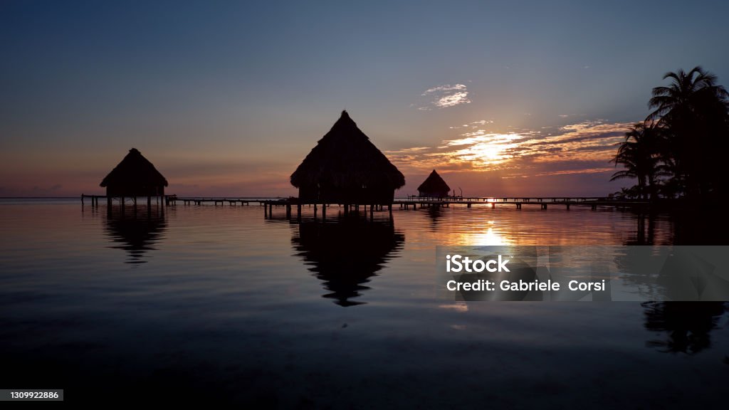 Sunrise A beautiful sunrise on the stilts of the hidden paradise of Glover's Atoll, one of the atolls that make up one of Belize's best-preserved reef ecosystems Awe Stock Photo