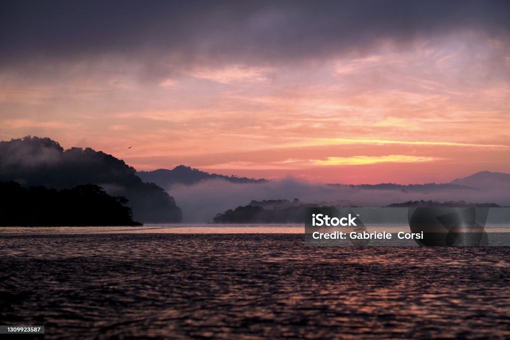 Dulce River A beautiful sunrise sailing on the Rio Dulce, Guatemala's beautiful river famous for its nature and biodiversity. The first light of day is also the best time to try and spot one of the wonders and rarities of Rio Dulce, the manatees Beauty Stock Photo