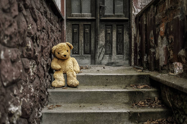 istock Brown teddy bear sitting on stairs 1309925066