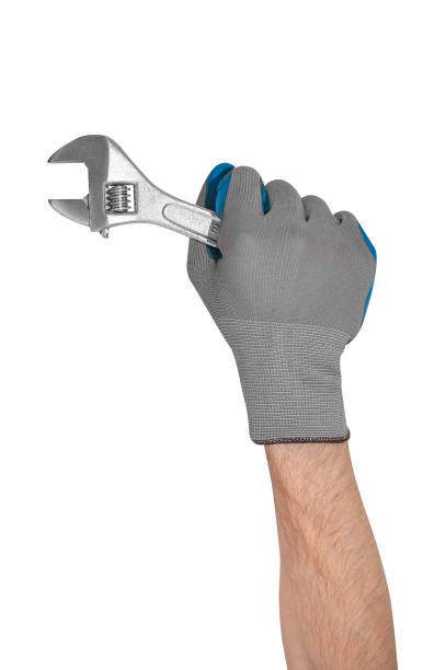 istock A man's gloved hand holds a monkey wrench. 1309926442