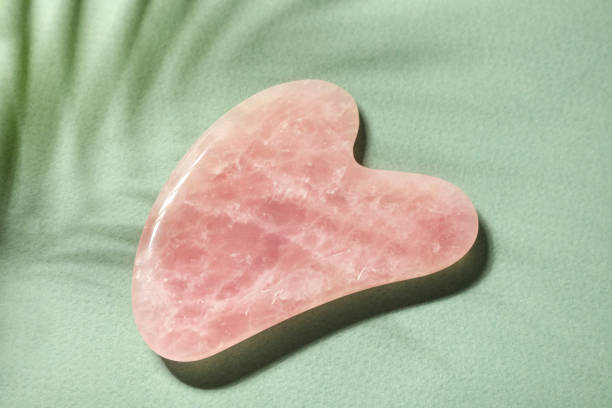 istock Rose quartz gua sha tool on green paper, top view 1309928047