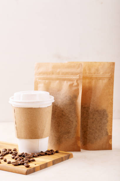 istock Take away paper cup of coffee and blank coffee packs 1309929892
