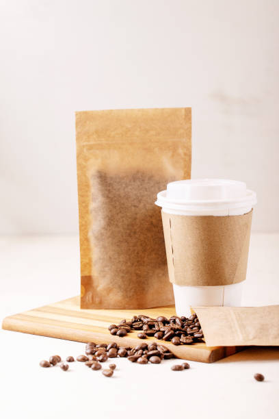 istock Take away paper cup of coffee and blank coffee packs 1309929894
