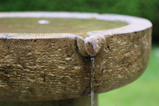 Close up of water gushing out of the pipe. Water is flowing from water pump through large pipe into an irrigation canal. High pressure crystal bluish sweet water flushing out industrial tube well.