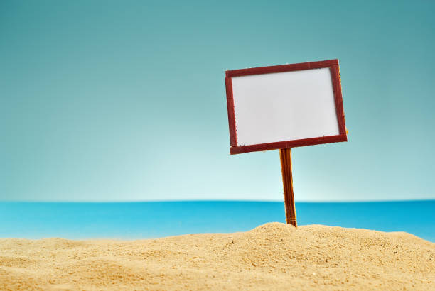 istock A sign for inscriptions on the beach. Copy space and free space for text on wooden pointer. Sunlight on the plate. Blue sea in the background. 1309930966