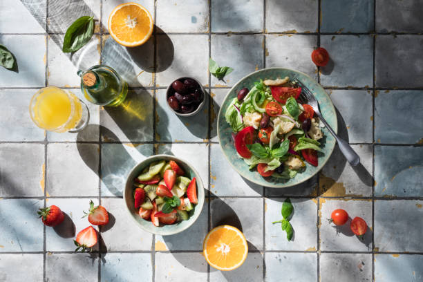 istock Mediterranean dishes at tiles table: vegetable and fruit salad, lemon and mint lemonade 1309931083