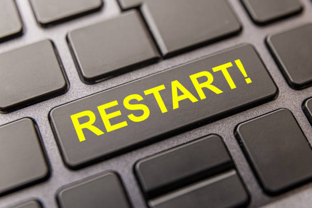 Black computer key with "restart!" in yellow capital letters. stock photo