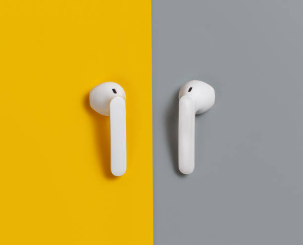 istock White wireless earphones on yellow and grey background 1309933196