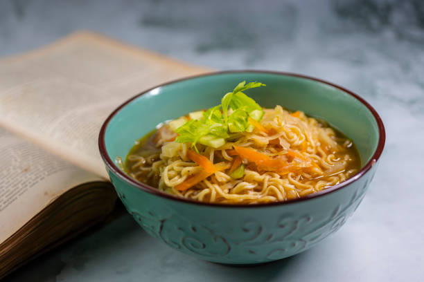 sopa de macarrão com livro de receitas antigo - tom tom yum meal soup - fotografias e filmes do acervo