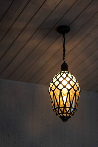 A luxury electric lamp in crystal shape or water droplet design during glowing in warming light for relaxation. Interior decorative object photo. Selective focus.