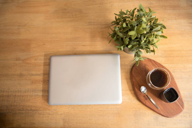 istock Top view office desk laptop and coffee cup on wood table copy space. Tabletop notebook laptop coffee cup for officer display empty space on wooden background. Home business work from home workspace 1309934948