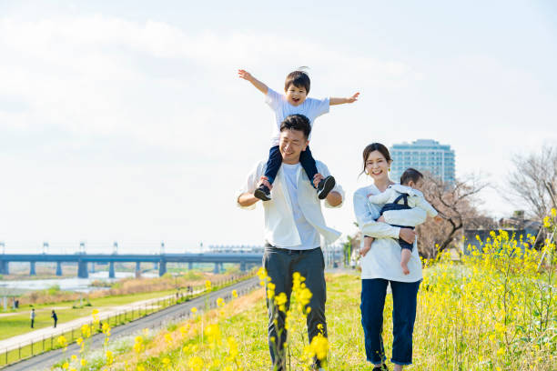 parents et enfants se promenant - family with two children family park child photos et images de collection