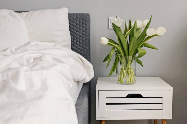 istock White tulips in a vase near the bed 1309935666