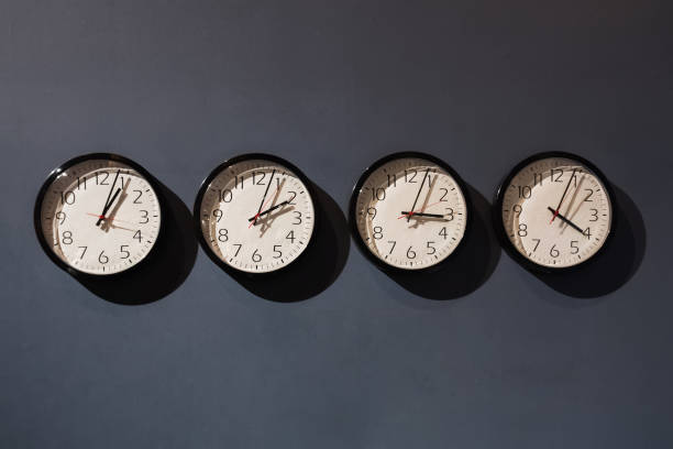 istock Four clocks on the black wall 1309935670