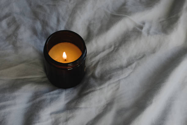 istock Burning wax aromatic candle on the bed. 1309935700