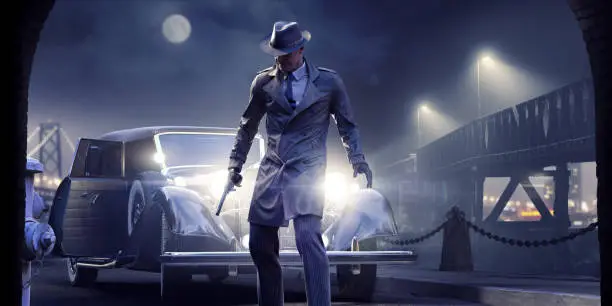 Elderly male film noir character dressed in shirt, tie, fedora hat and pin stripe trousers holding a gun and looking down. The man stands in front of the bright headlights of a 1940s car on a quiet side street at night close to an iron bridge with distant city lights.