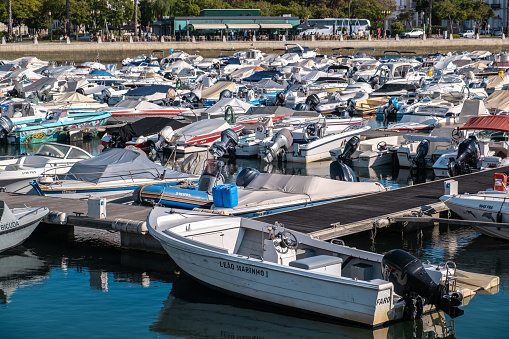 Boats Parked At Faro Marina With Water Reflection In Algarve, Portugal At Sunny Summer.